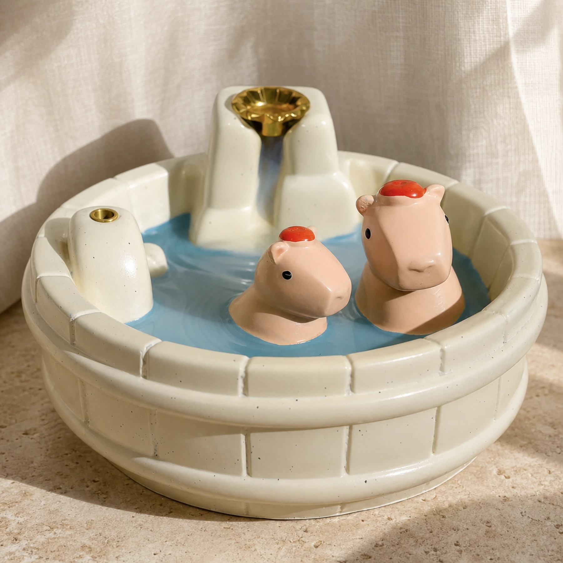 White resin capybara incense burner detail showing two pink capybaras and the brass cone and stick-incense holders