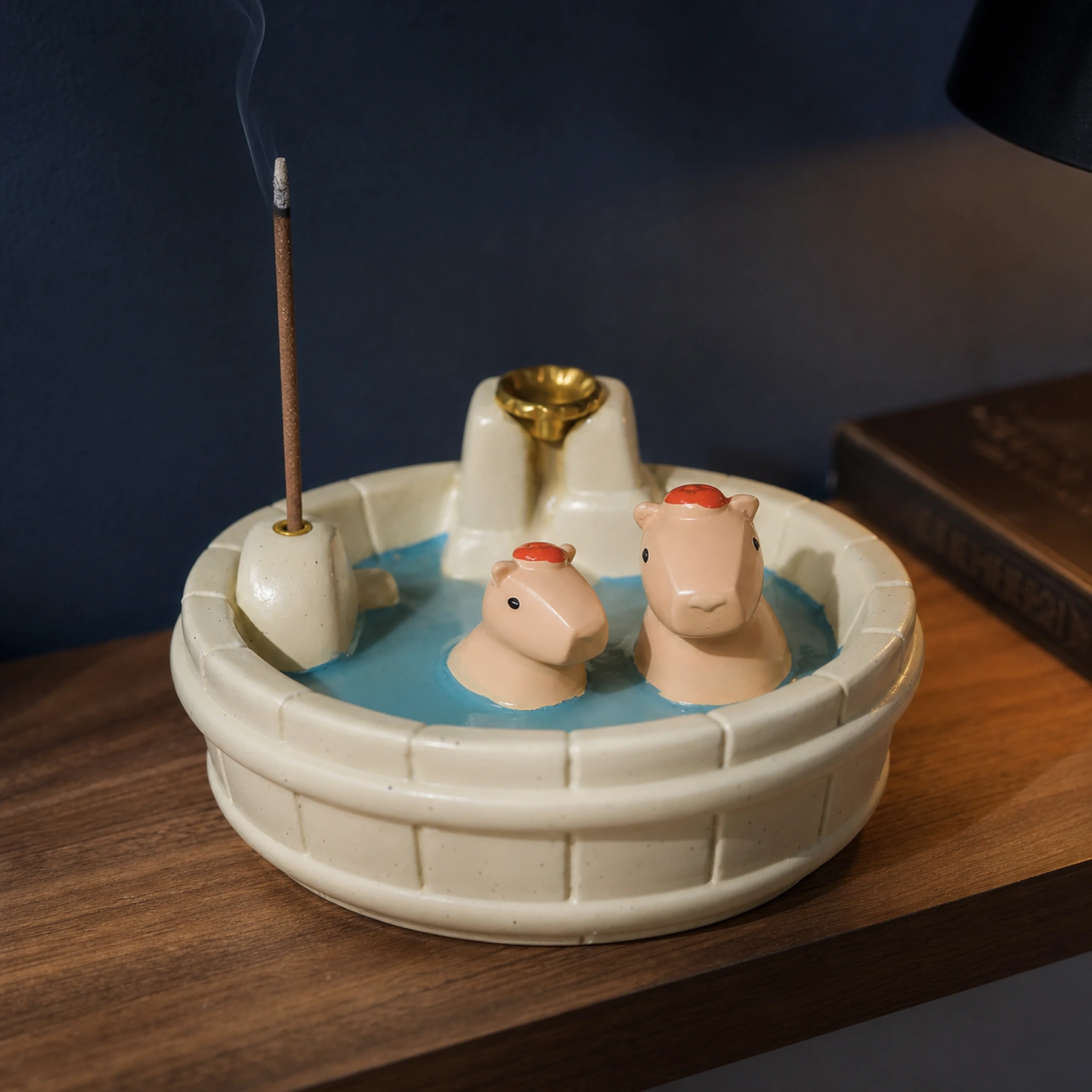 White resin capybara incense burner using stick incense in the separate left brass-lined hole