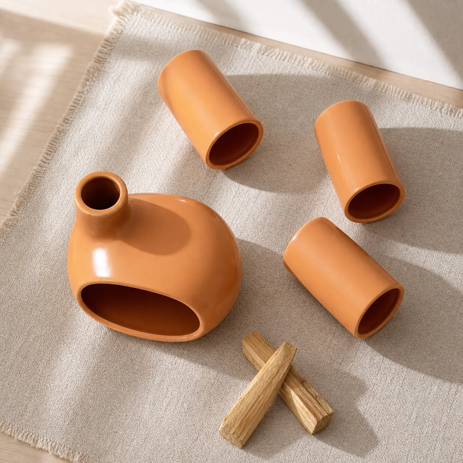 Complete four-piece ceramic Palo Santo burner set arranged on oatmeal linen