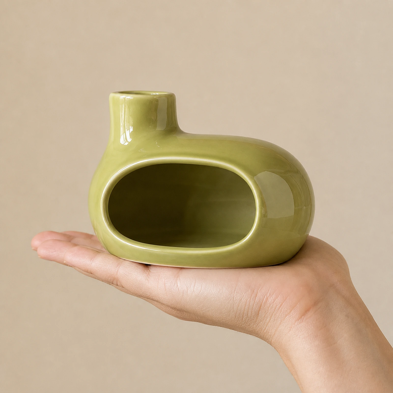 Emerald green Classic Ceramic Palo Santo & Sage Burner, held in an adult hand to show approximate tabletop scale.