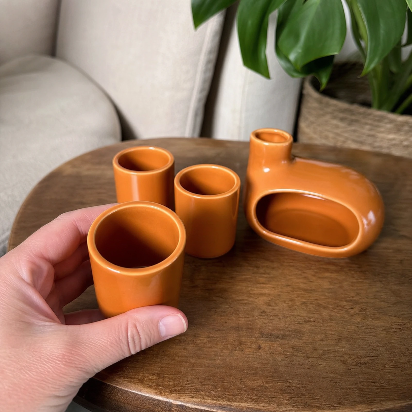 Glazed orange burner and three-holder set Classic Ceramic Palo Santo & Sage Burner, held in an adult hand to show approximate tabletop scale.