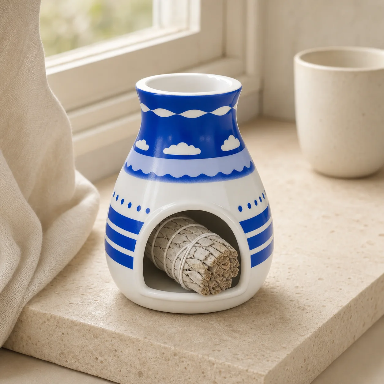 Hopi blue ceramic Palo Santo holder styled with white sage by a window