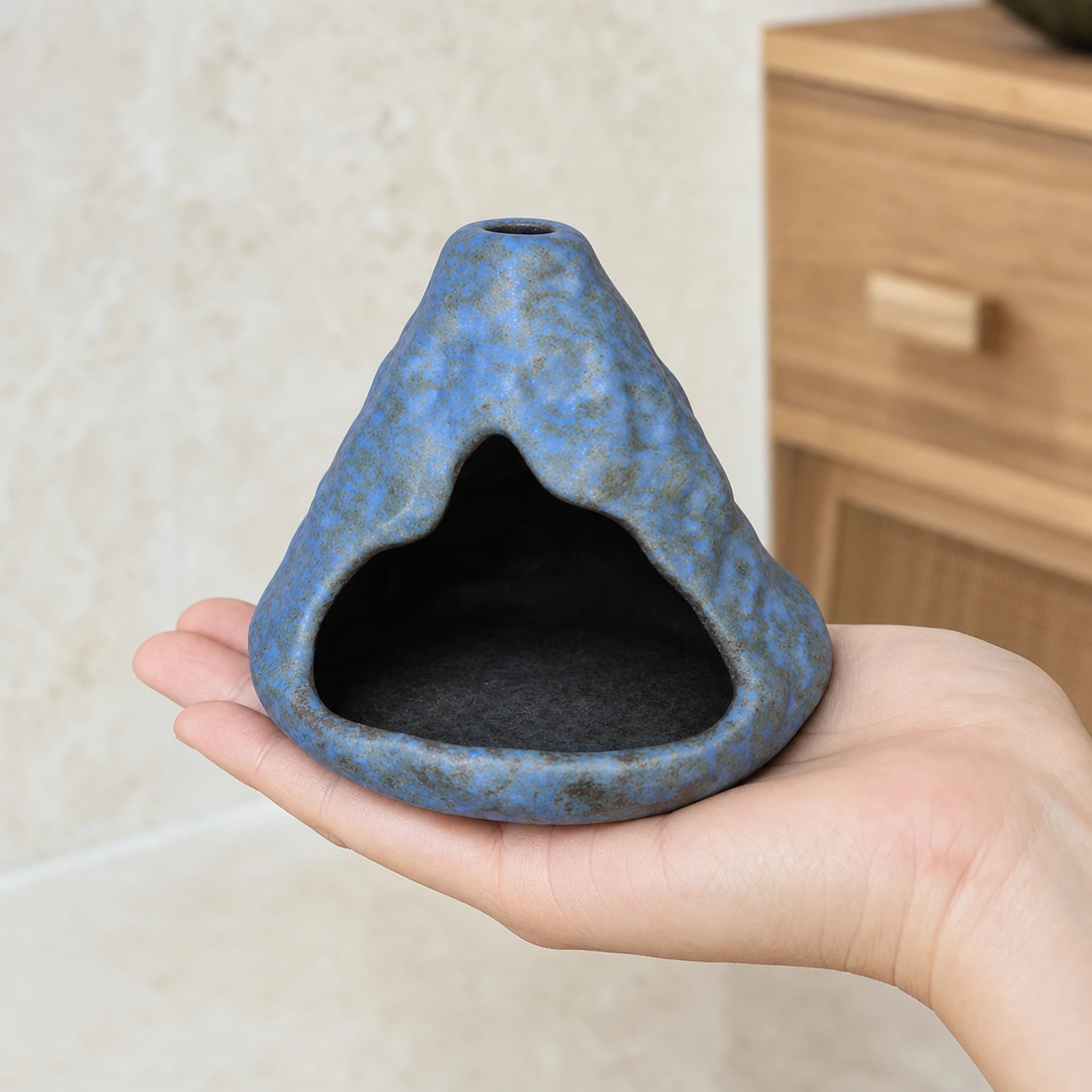 Light Blue ceramic zongzi incense holder supported in one hand to show tabletop scale