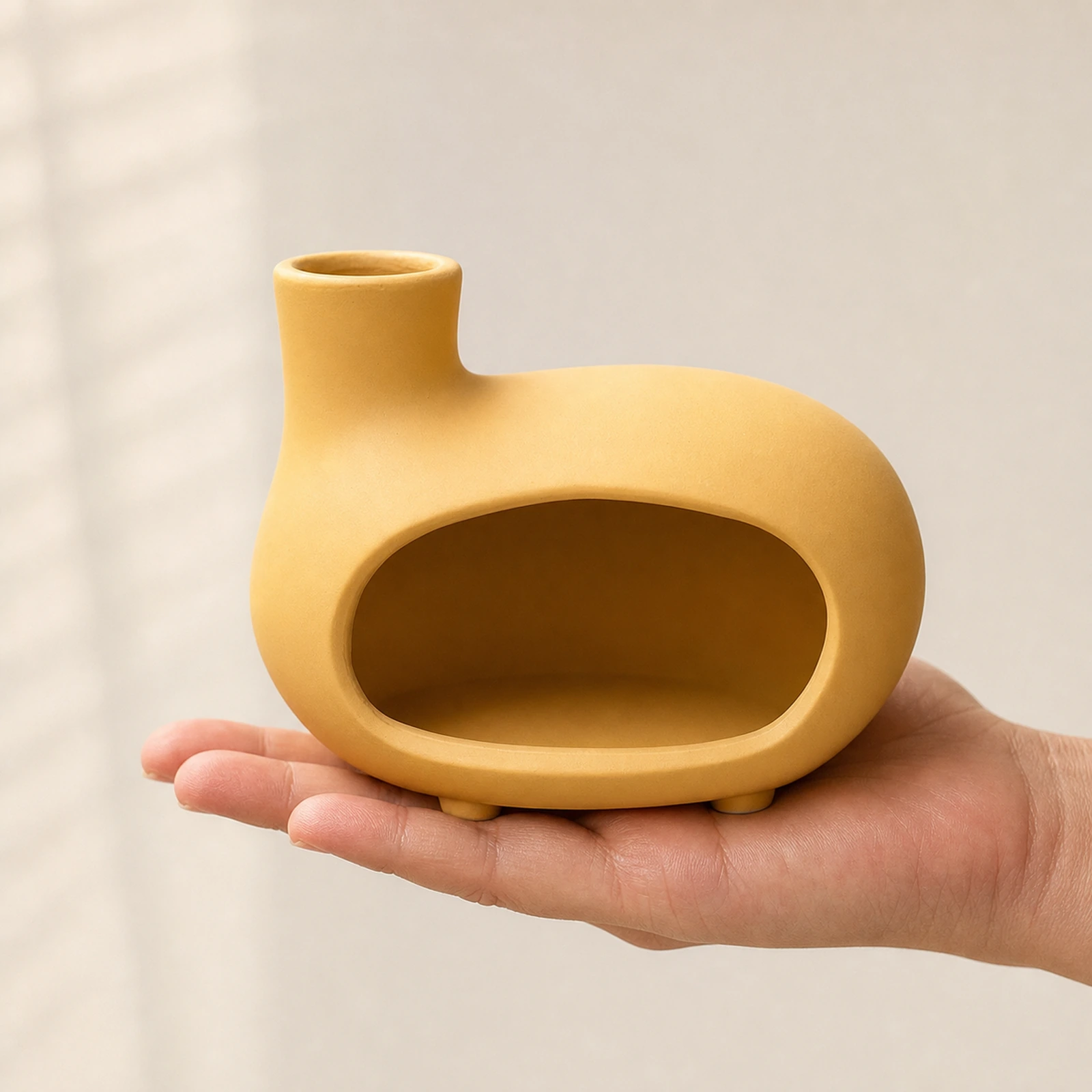 Matte yellow short-foot Classic Ceramic Palo Santo & Sage Burner, held in an adult hand to show approximate tabletop scale.