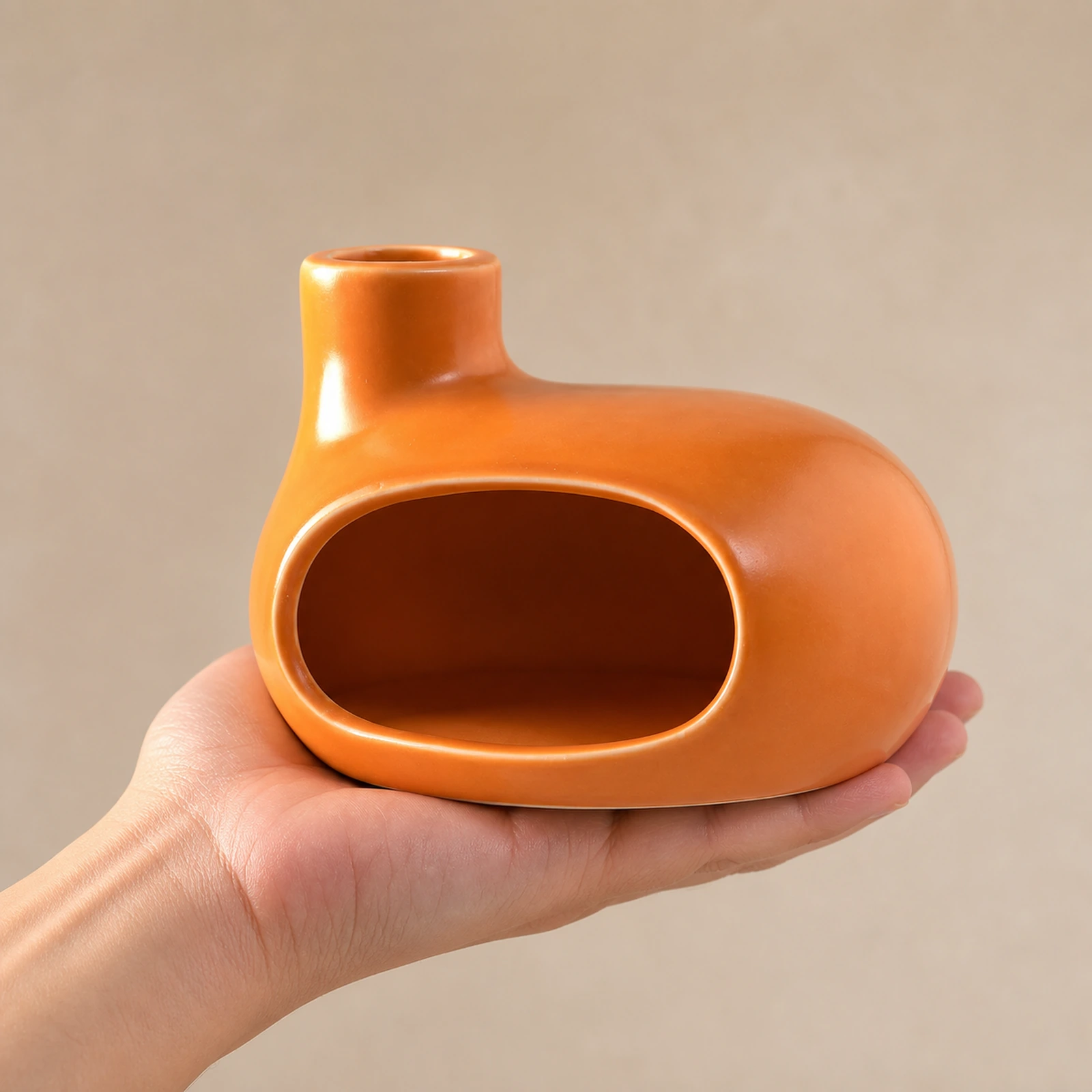 Orange Classic Ceramic Palo Santo & Sage Burner, held in an adult hand to show approximate tabletop scale.