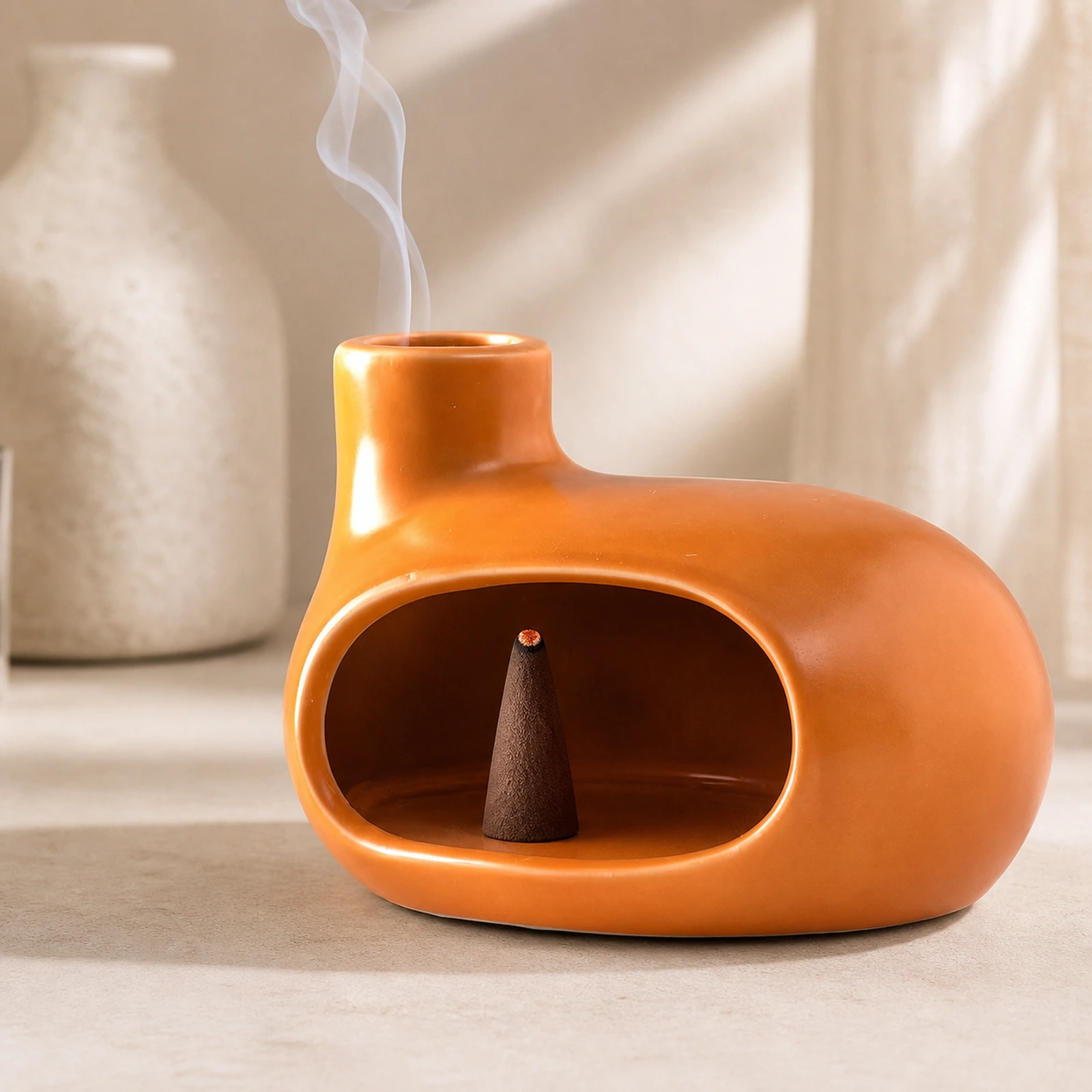 Orange Classic Ceramic Palo Santo & Sage Burner, using a tapered incense cone with smoke exiting the top vent.