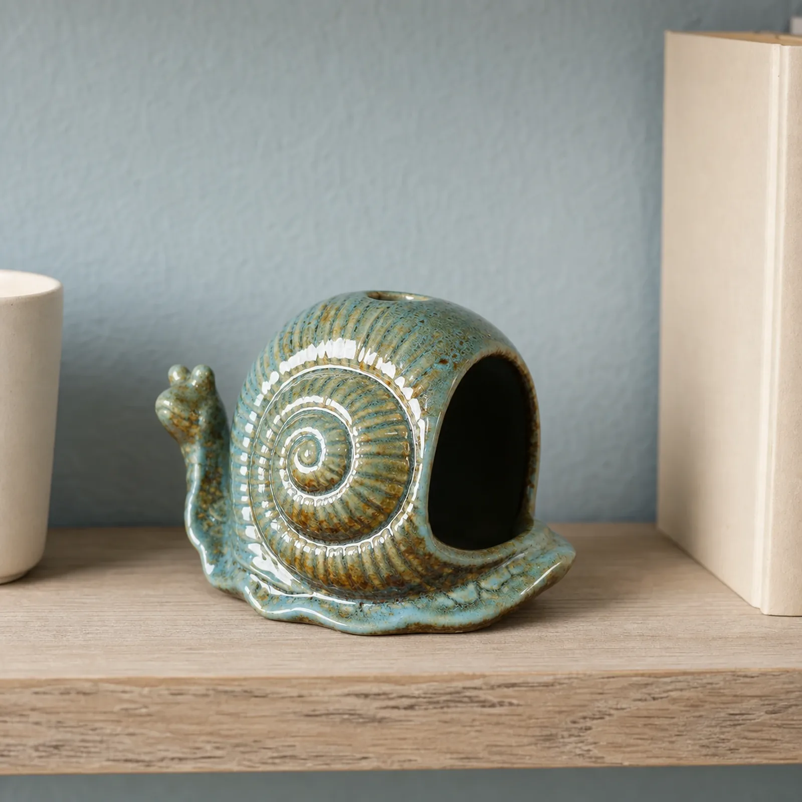 Blue ceramic snail incense holder styled in an everyday home setting