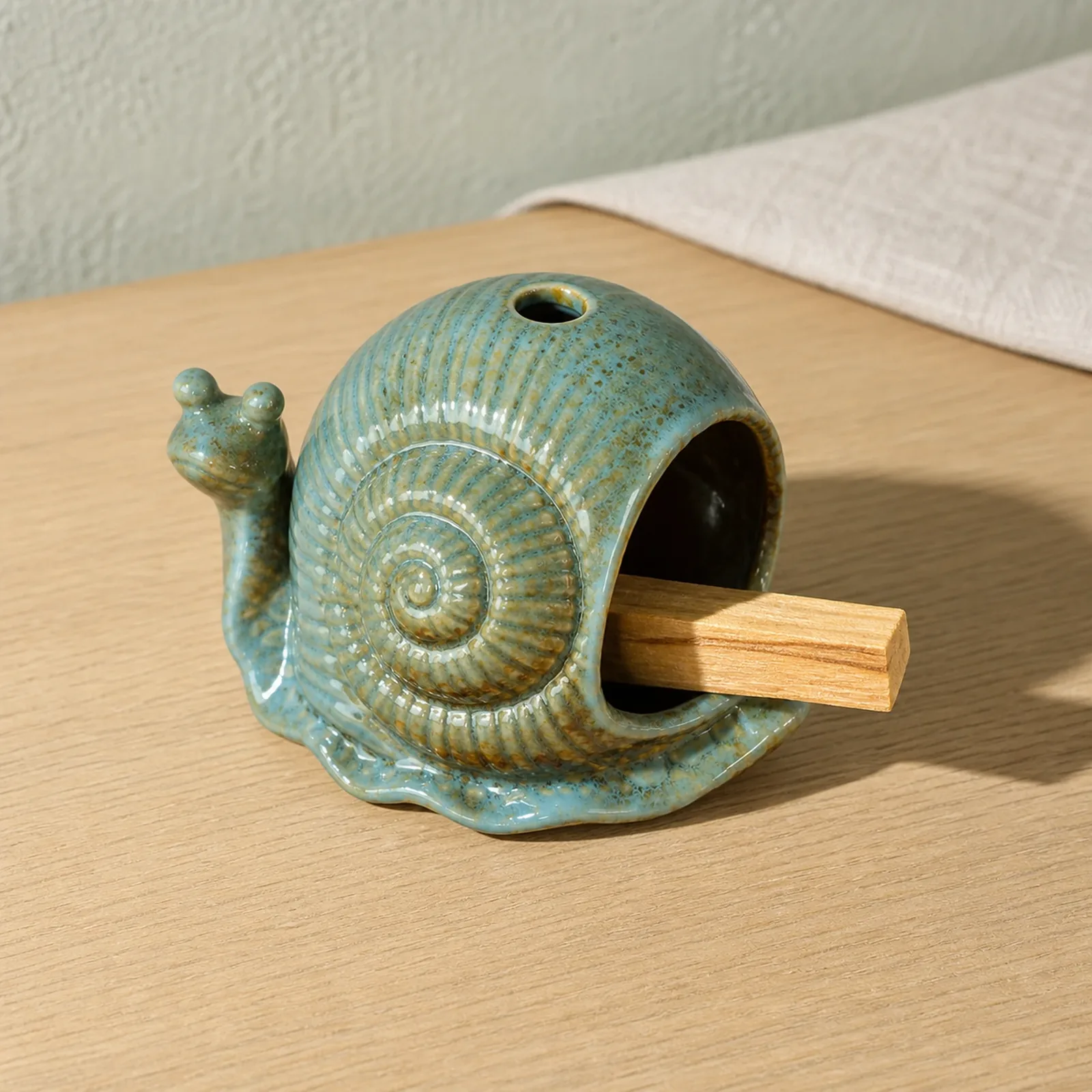 Blue ceramic snail Palo Santo holder showing smoke-free wood placement in the front chamber