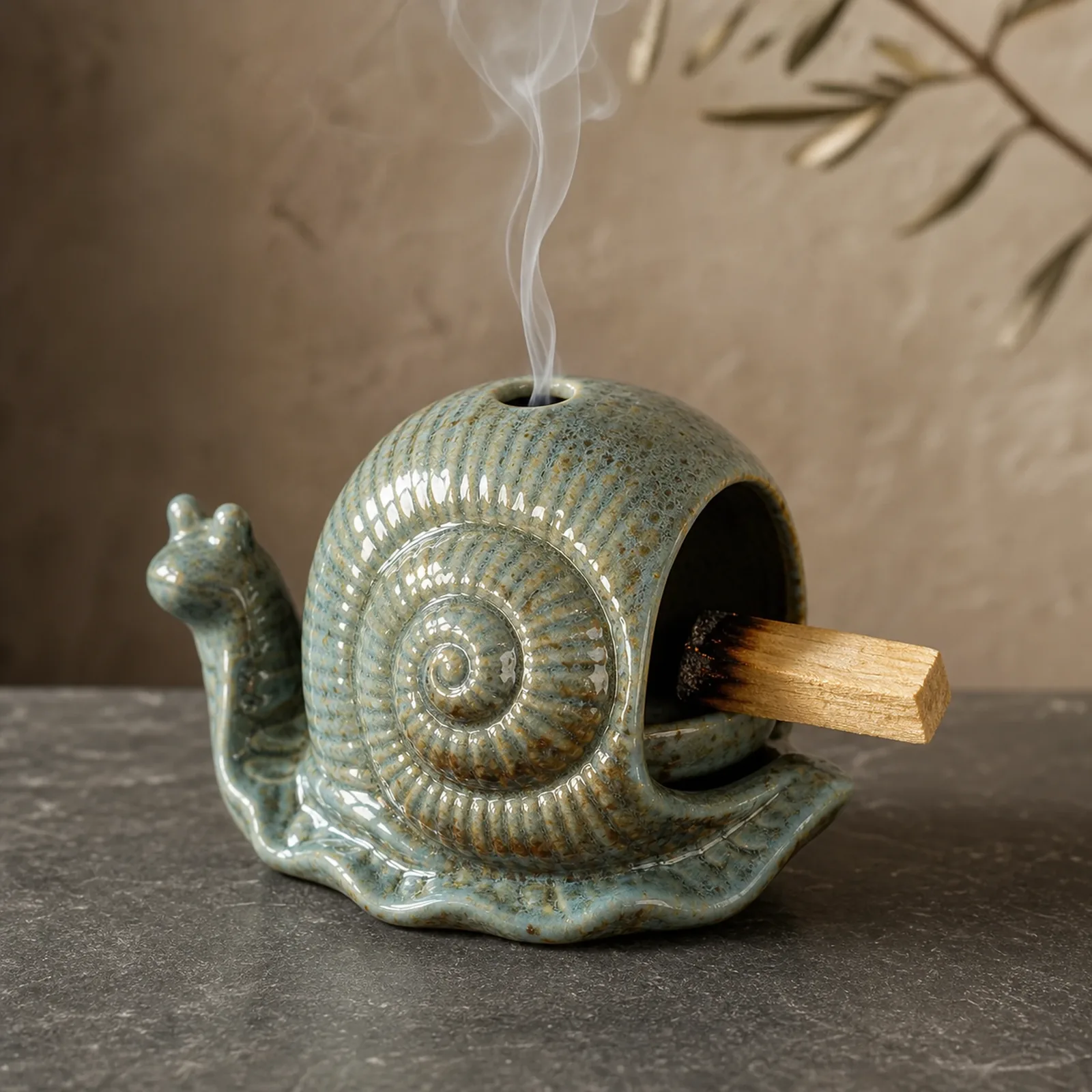 Blue ceramic snail Palo Santo holder with a visible charred ember and thin smoke rising through the top vent