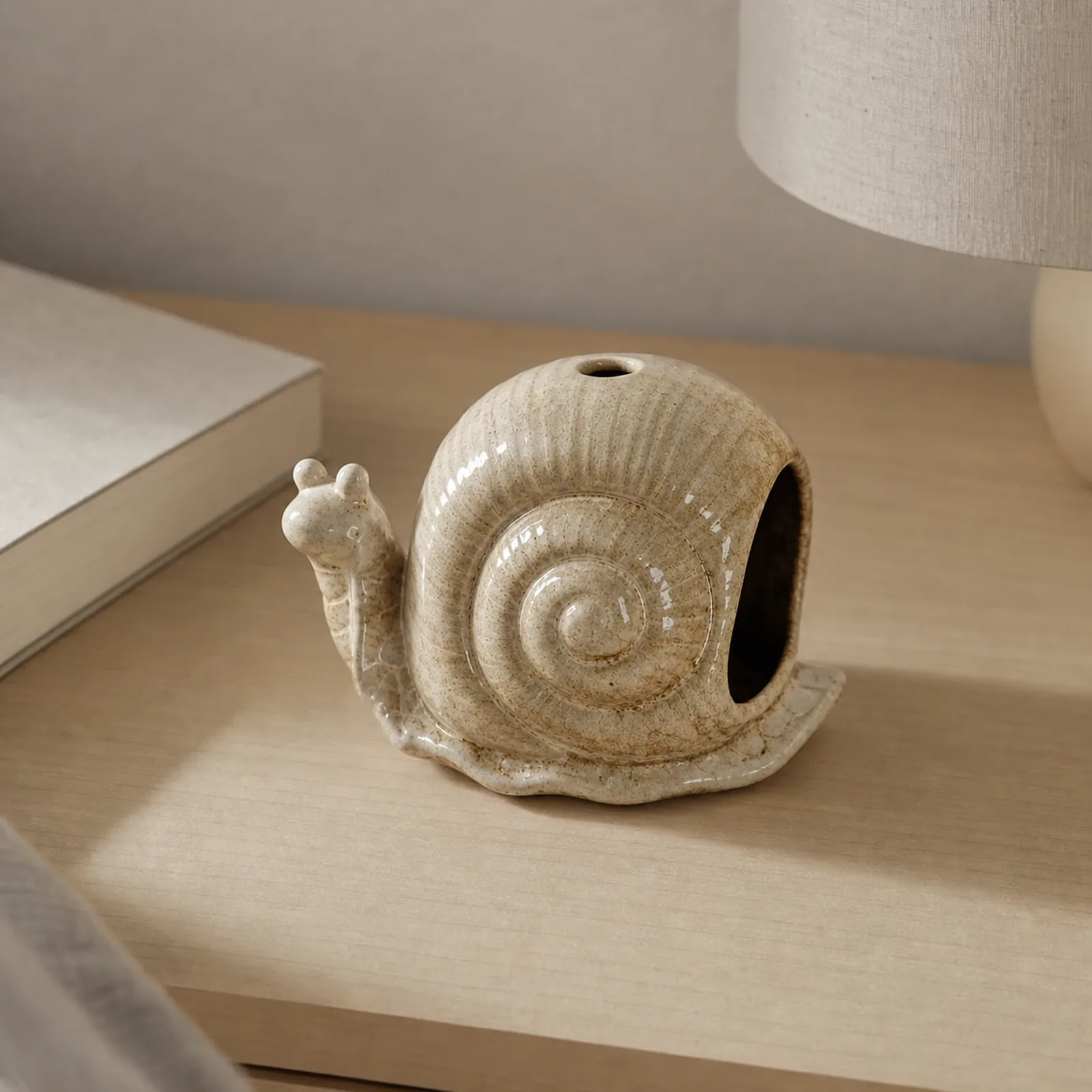 Brown ceramic snail incense holder styled in an everyday home setting