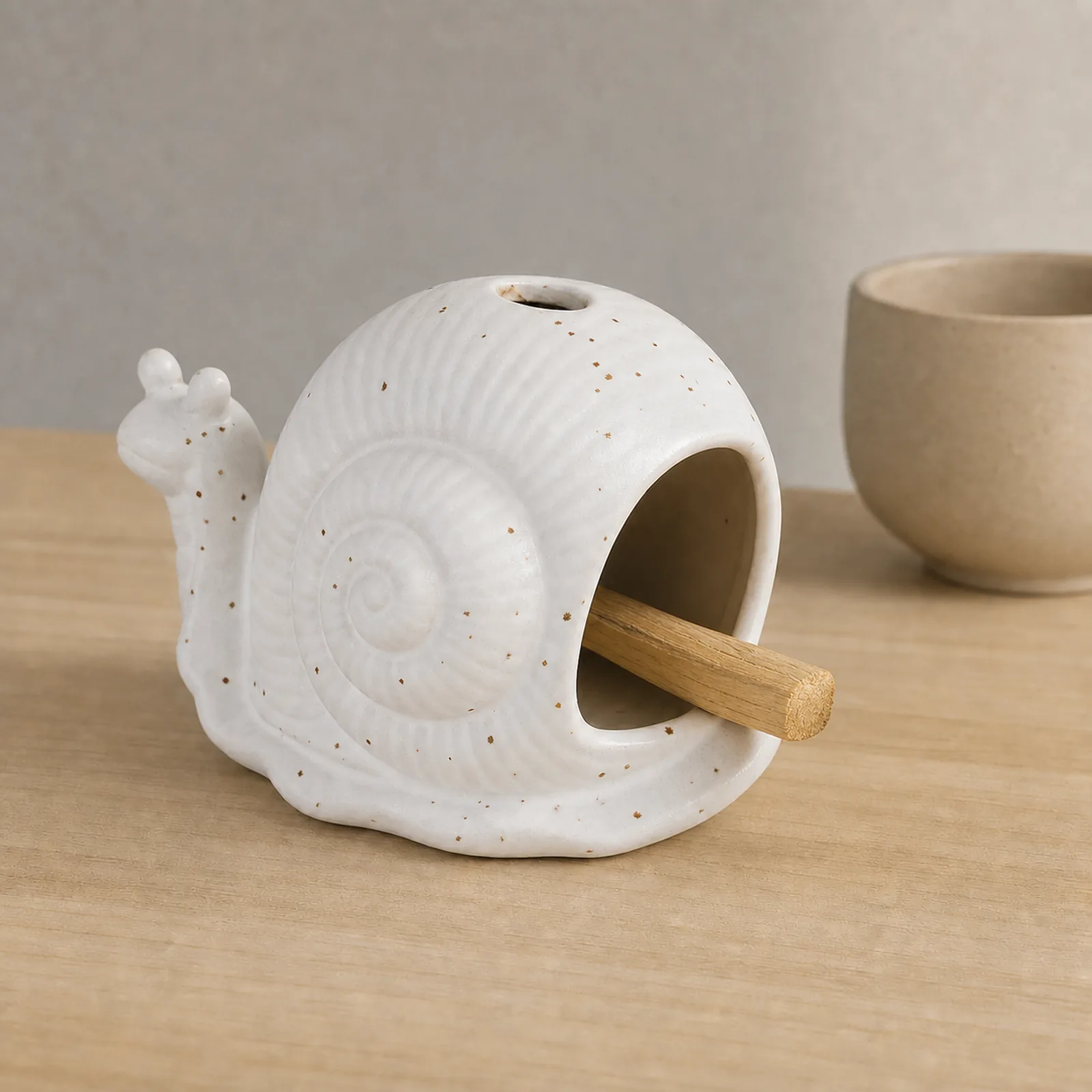 White ceramic snail Palo Santo holder showing smoke-free wood placement in the front chamber