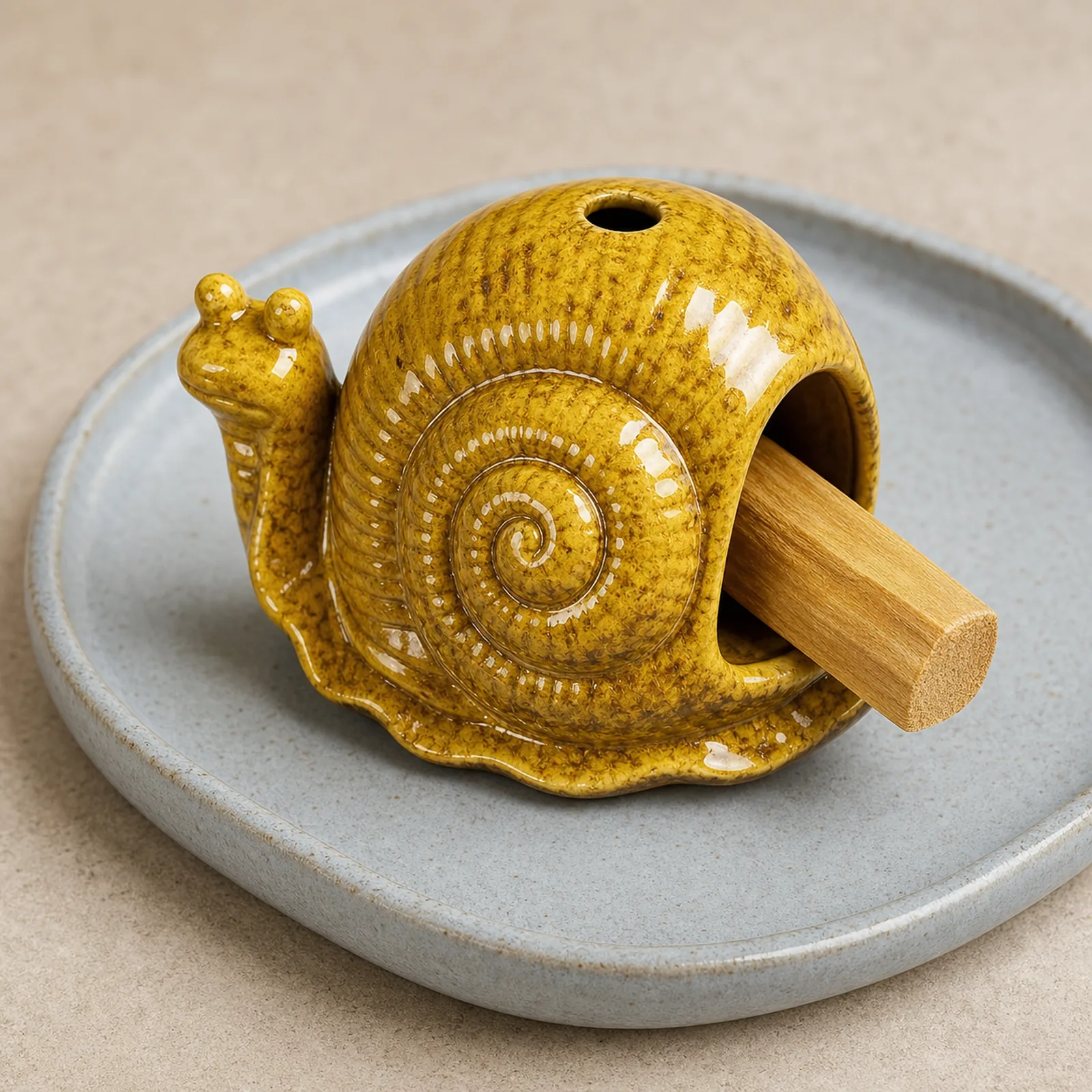 Yellow ceramic snail Palo Santo holder showing smoke-free wood placement in the front chamber