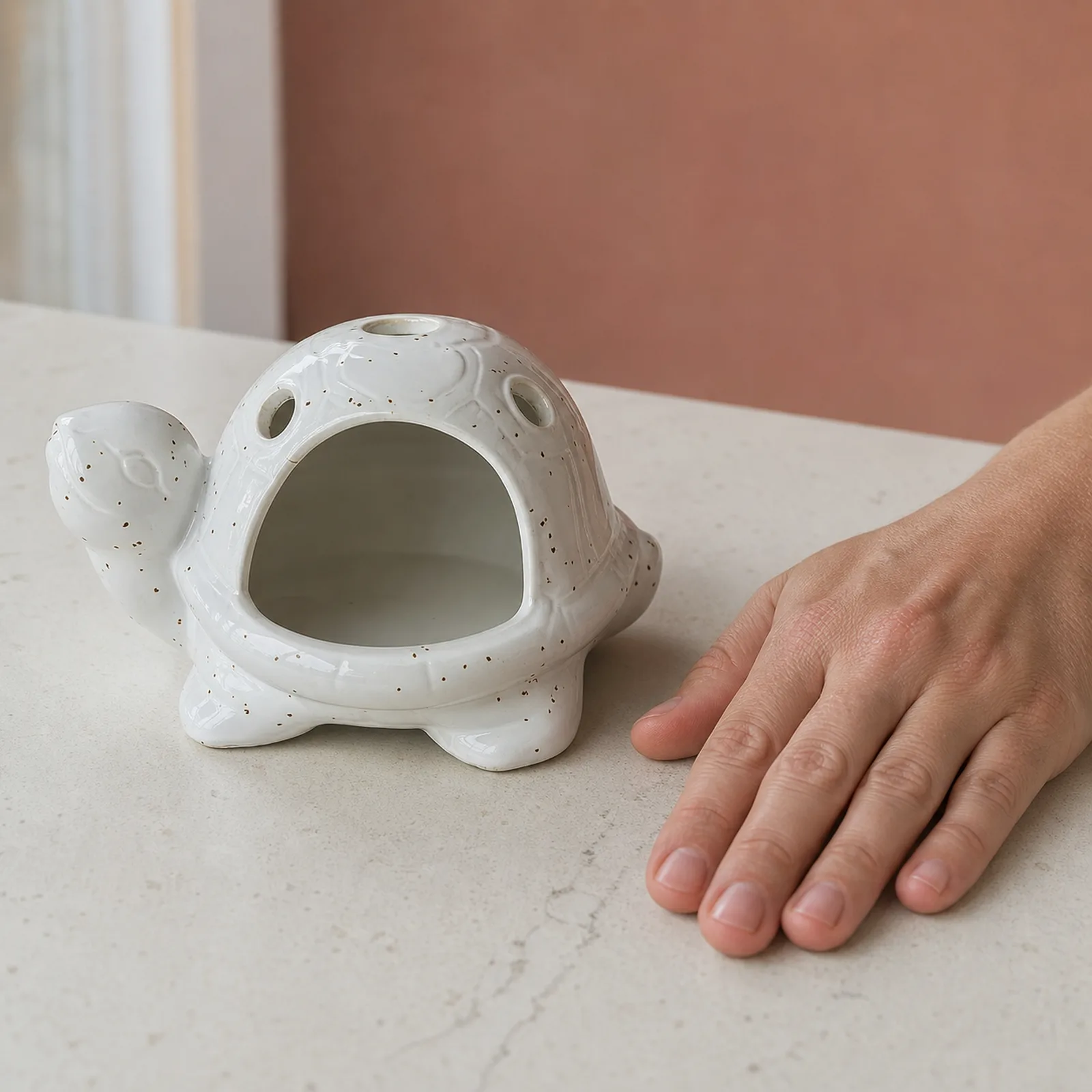 White speckled ceramic turtle Palo Santo holder hand scale view