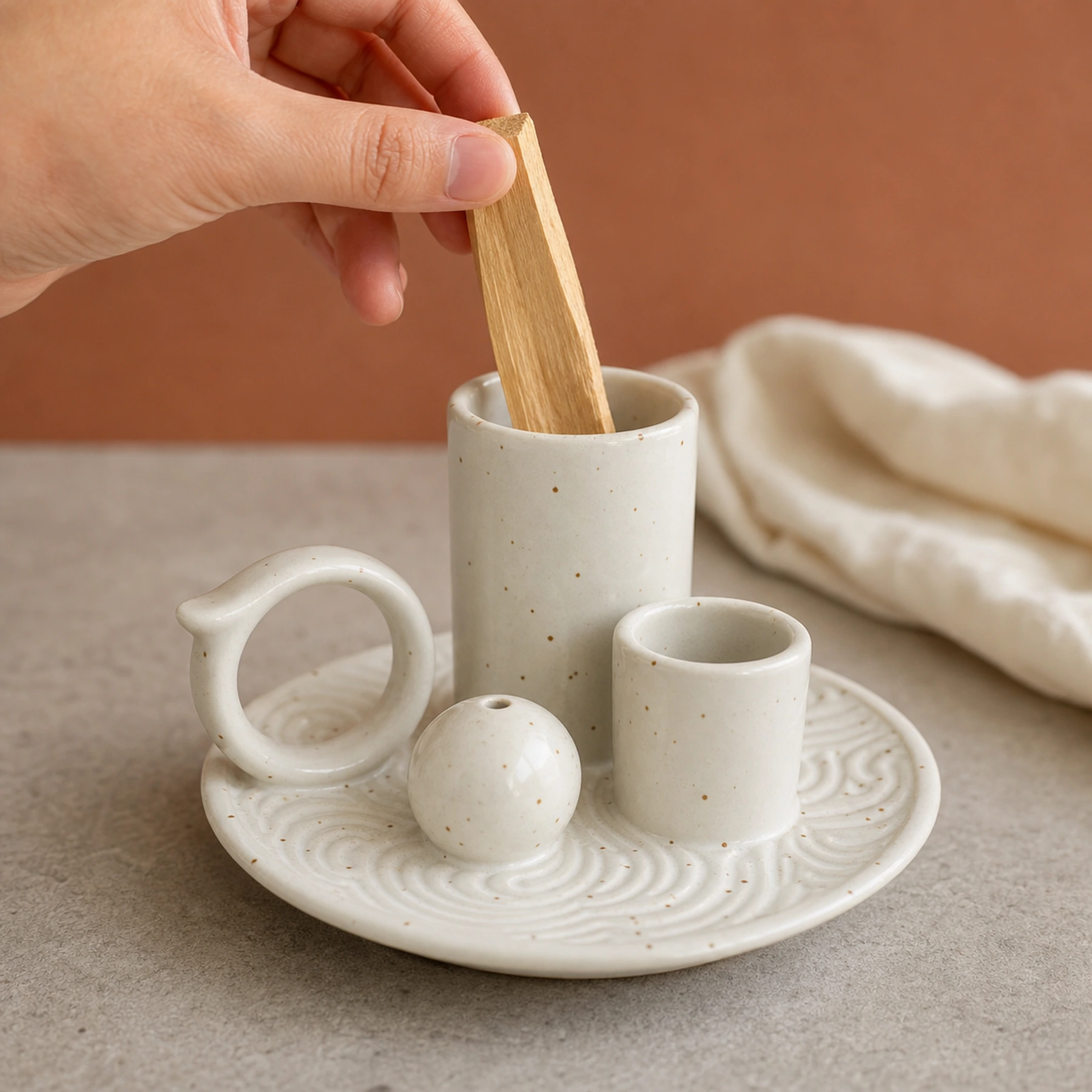 White glaze 5-in-1 ceramic smudge bowl shown with an adult hand for tabletop scale