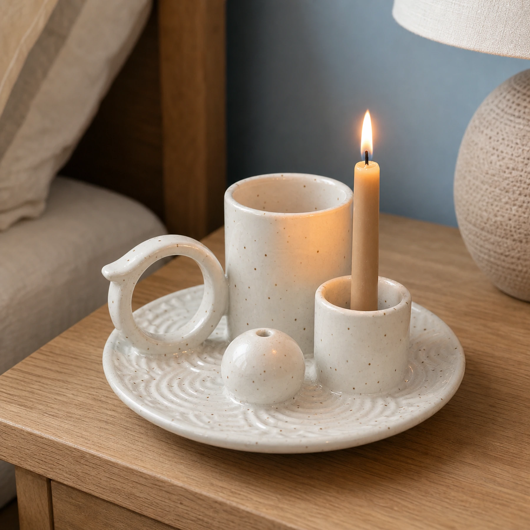 White glaze 5-in-1 ceramic smudge bowl holding a lit taper candle with a natural flame
