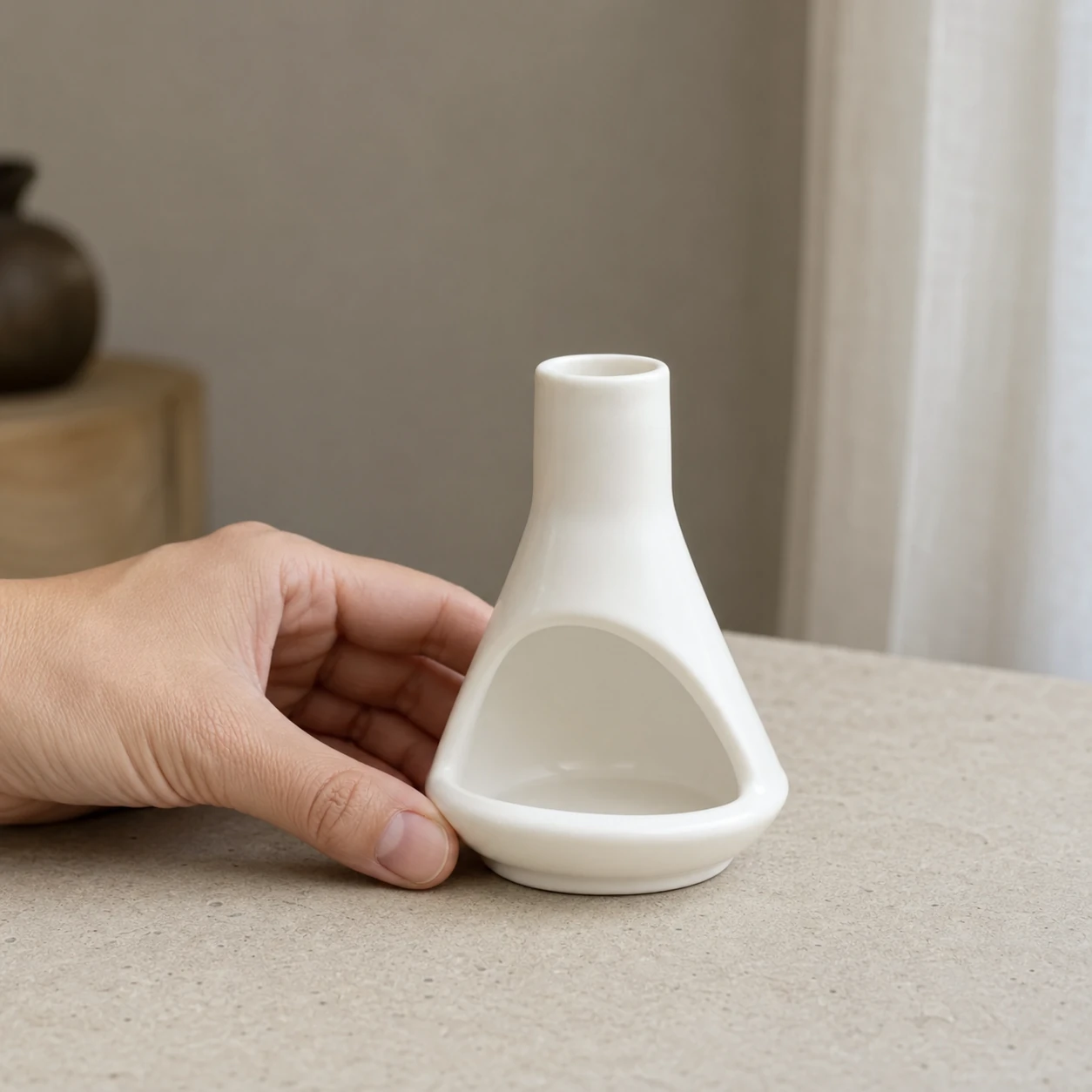 White ceramic mini chiminea shown at hand scale