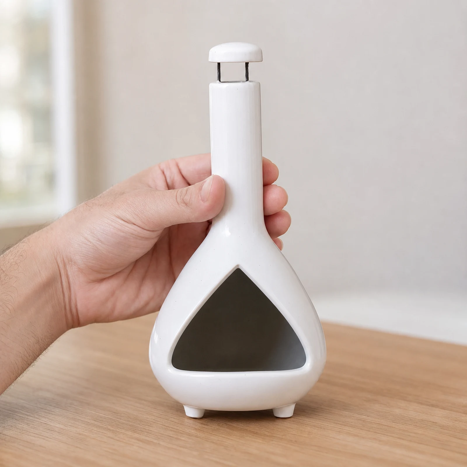 White ceramic Palo Santo holder held in one hand to show the product scale
