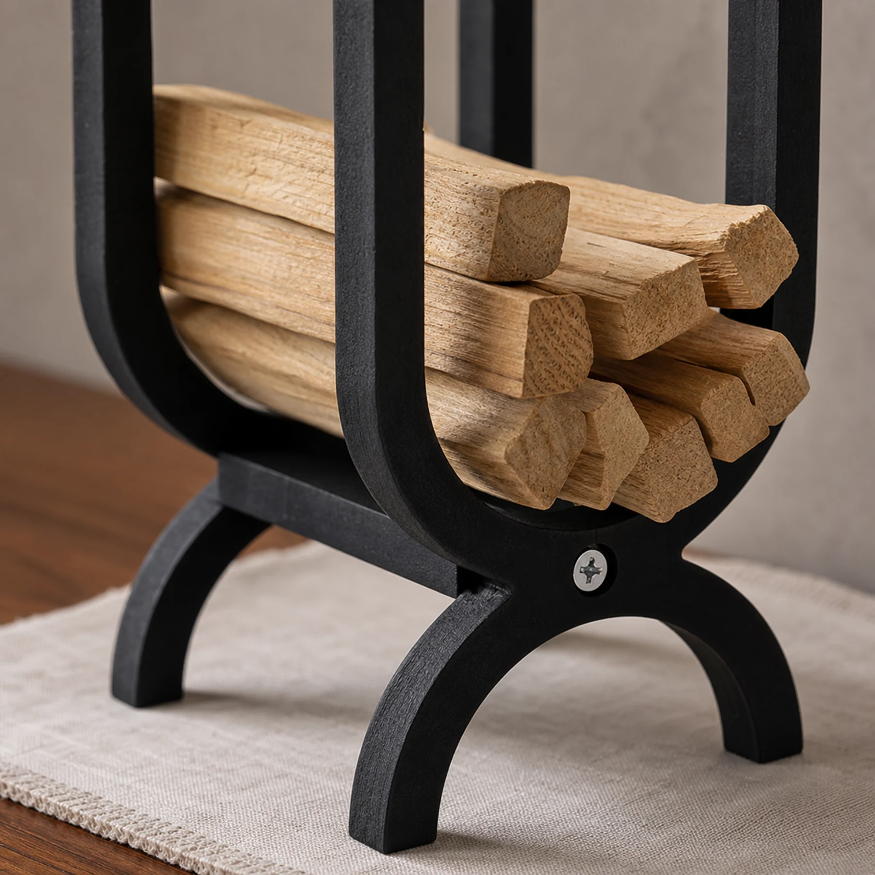 Close detail of the dark wood storage organizer frame, curved cradle, arched foot, and front fastener