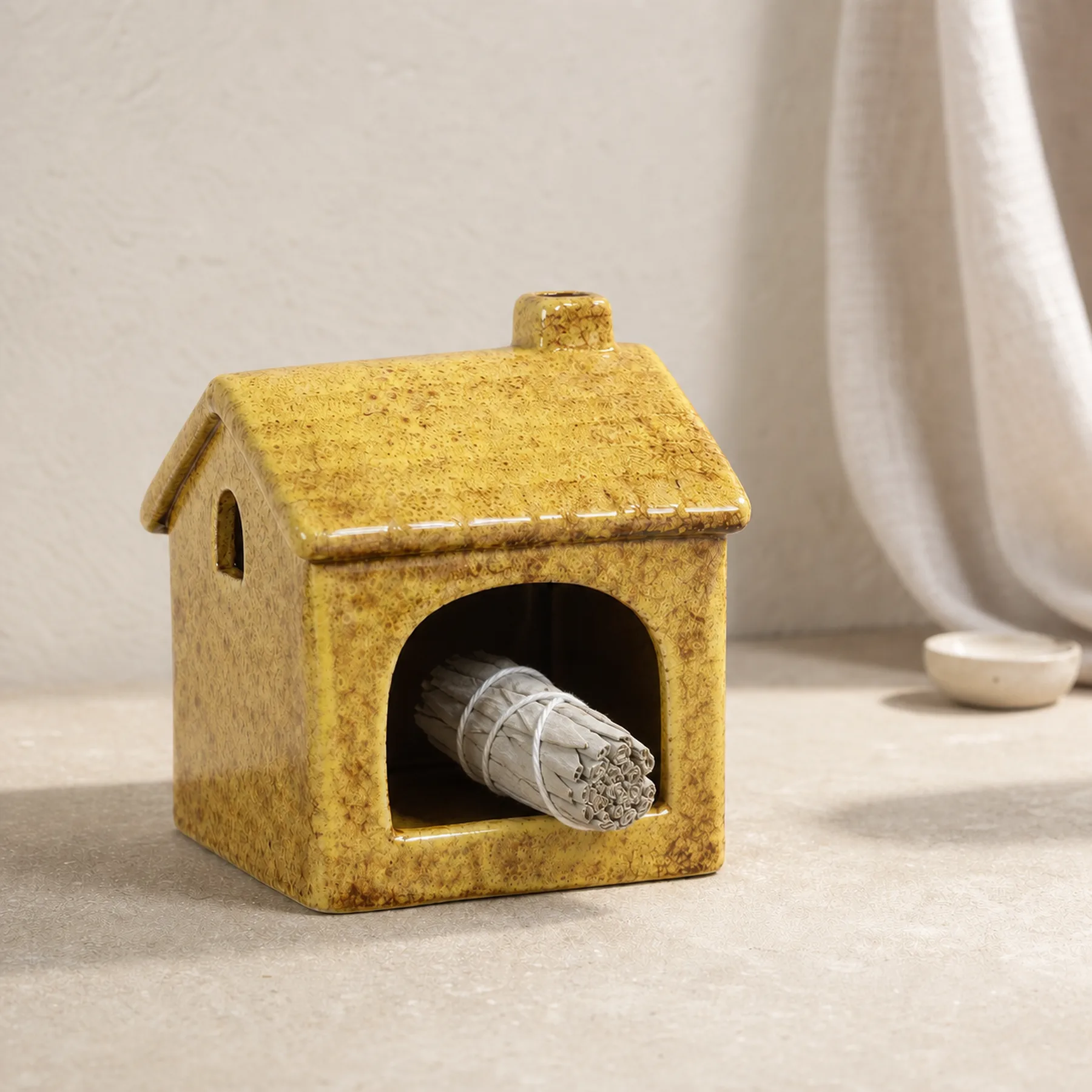 Yellow ceramic house Palo Santo holder material and use detail
