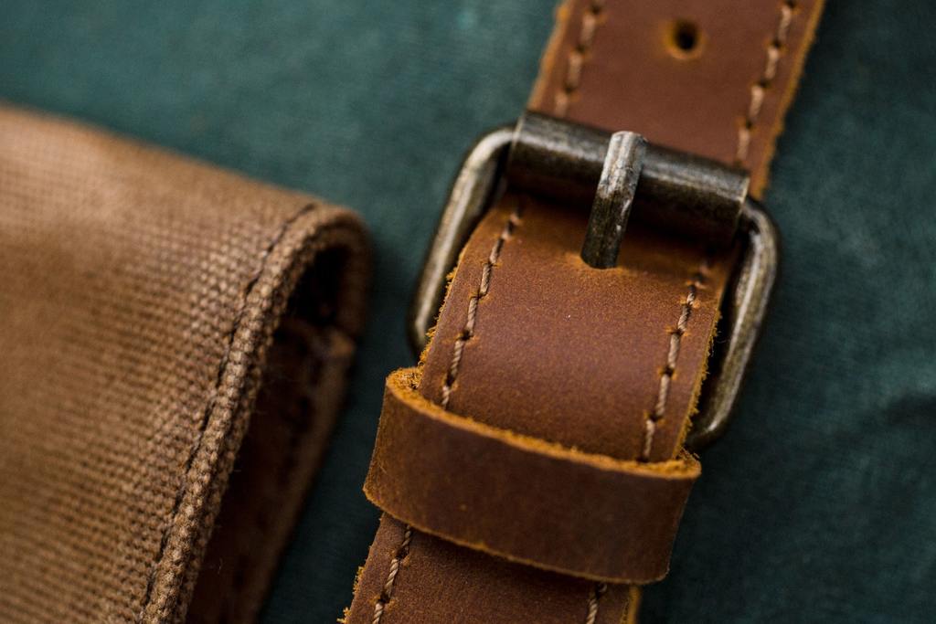 boucle m&eacute;tallique en laiton et sangle en cuir pleine fleur d'un sac toile vintage de couleur vert &eacute;meraude