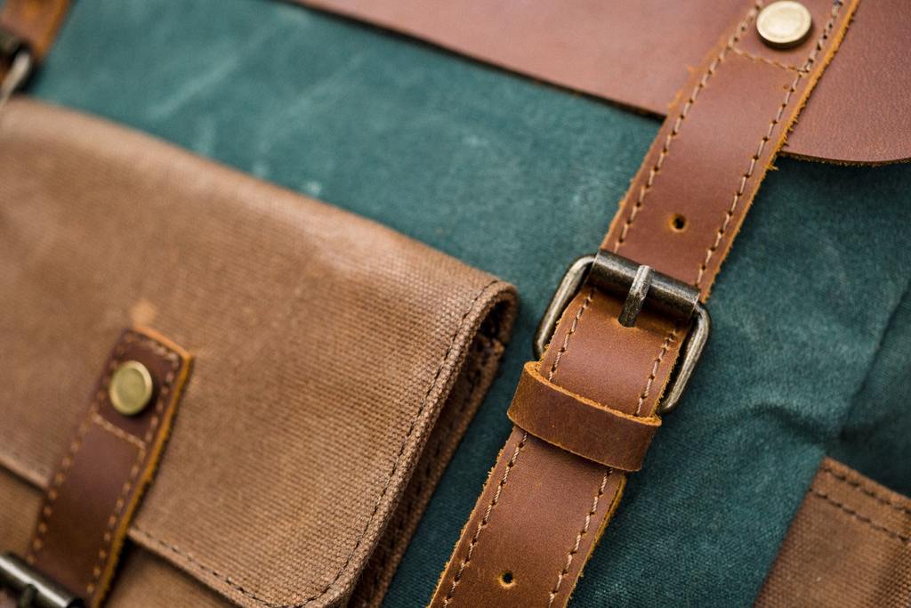 Poche avant &agrave; rabat boucl&eacute; et syst&egrave;me de fermeture &agrave; boucle sur sangle en cuir d'un sac &agrave; dos homme vintage en toile de coton et cuir vintage