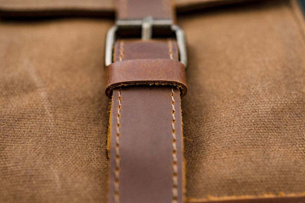 sangle en cuir et fermoirs m&eacute;tallique de la poche ext&eacute;rieure d'un sac &agrave; dos flaneur tendance et r&eacute;tro en cuir v&eacute;ritable et toile canevas