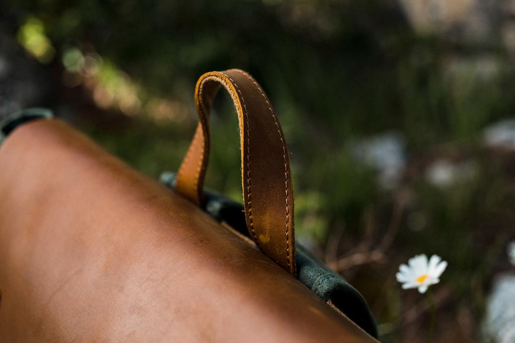 poign&eacute;e surpp&eacute;rieure en cuir doubl&eacute; de coton et rabat en cuir crazy horse marron d'un sac &agrave; dos moto vintage d&eacute;perlant et robuste