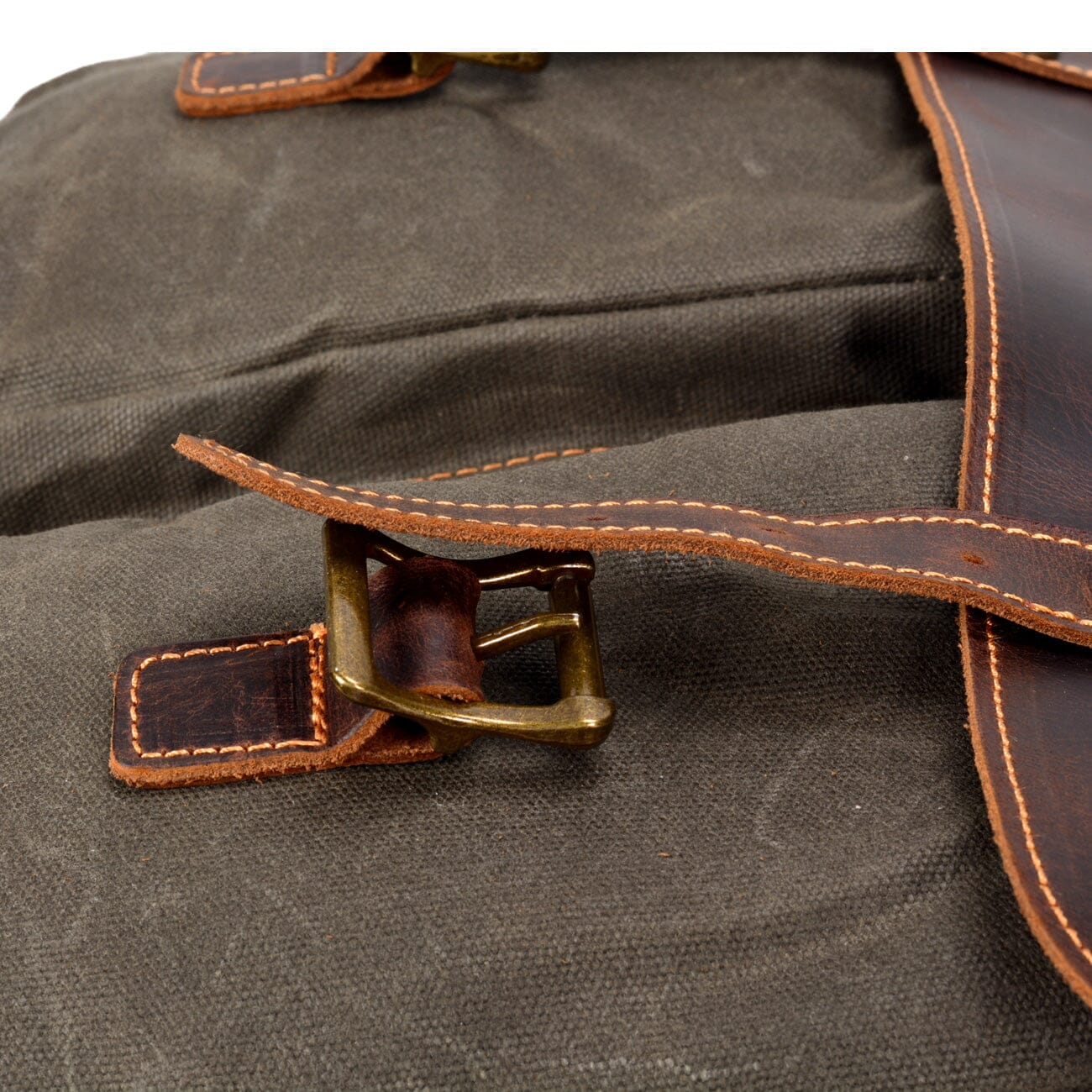 close up of the leather straps. brass buckle and sturdy stitching of the vintage messenger bag from eiken. tulsa model