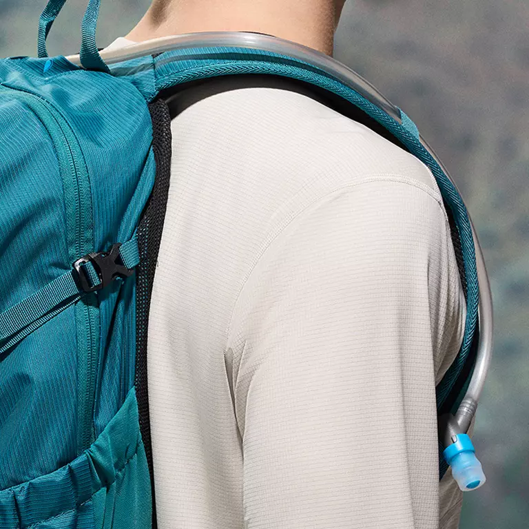 Close-up of a woman buttoning a Silver Ridge shirt. 