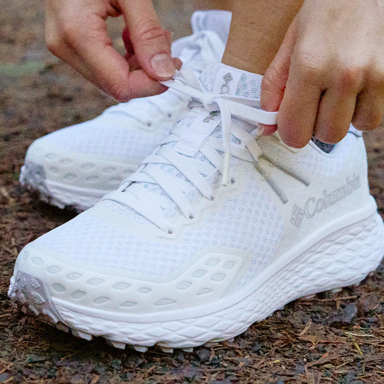Close up shot of a person tieing the Konos laces