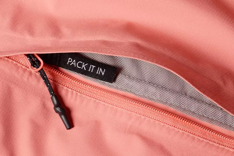 An image of the jacket being packed into the hand pocket