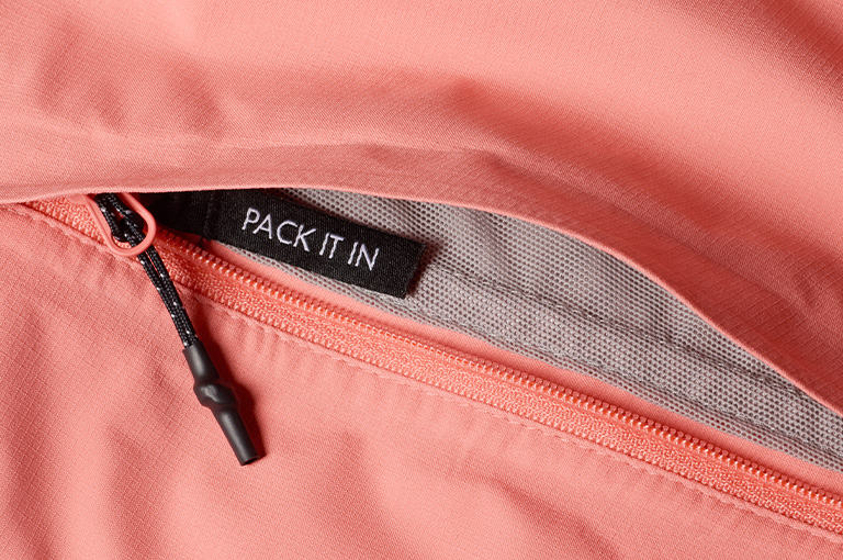 An image of the jacket being packed into the hand pocket