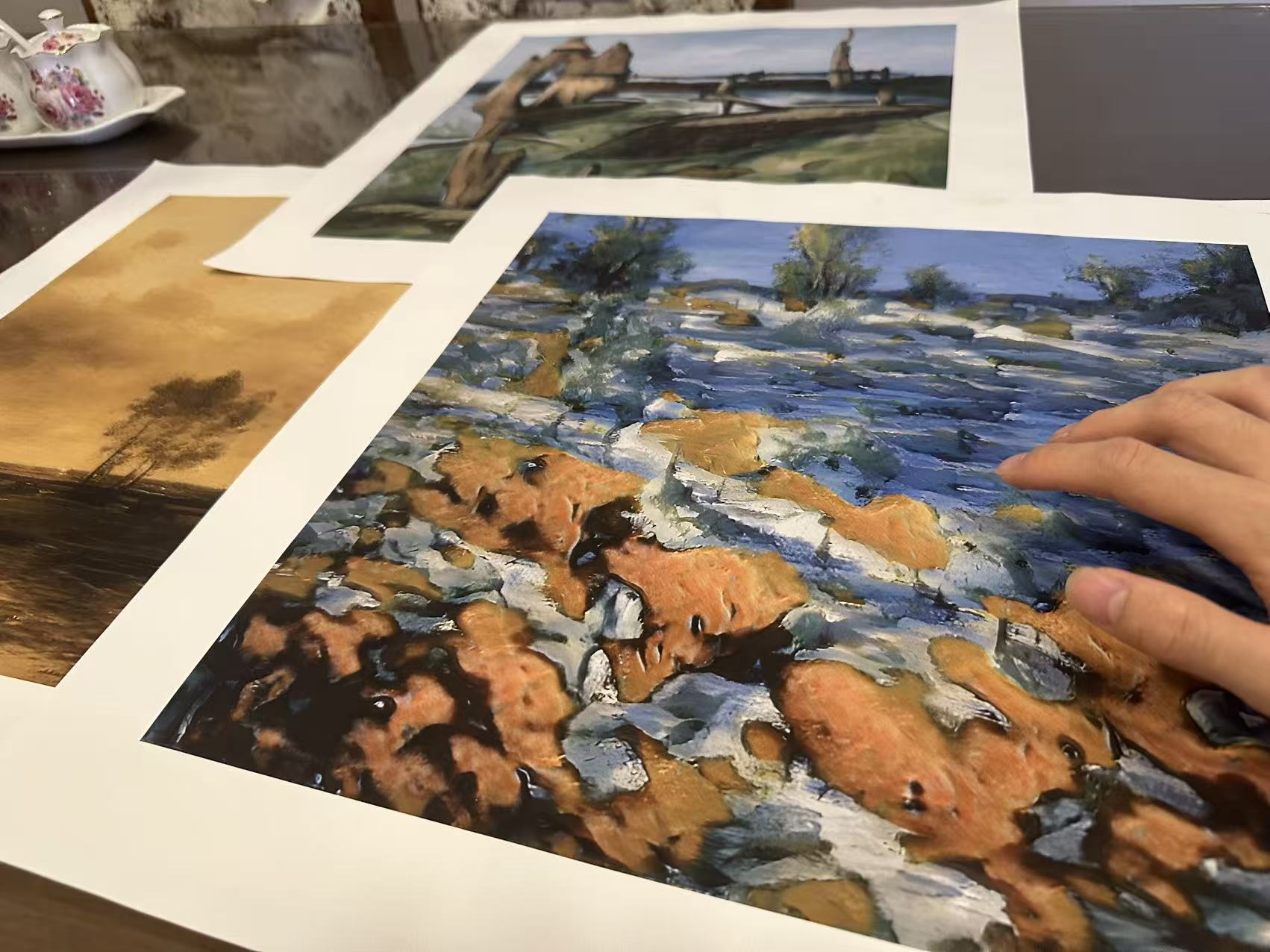 A real Whispart studio process photograph showing printed canvases being compared and flawed copies set aside.