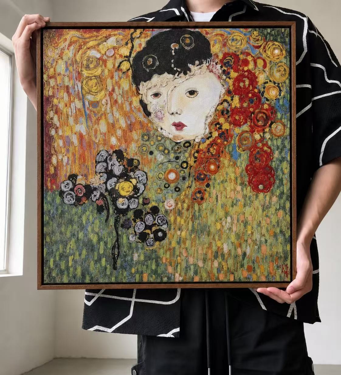 The founder of Whispart holding the first framed artwork in the studio