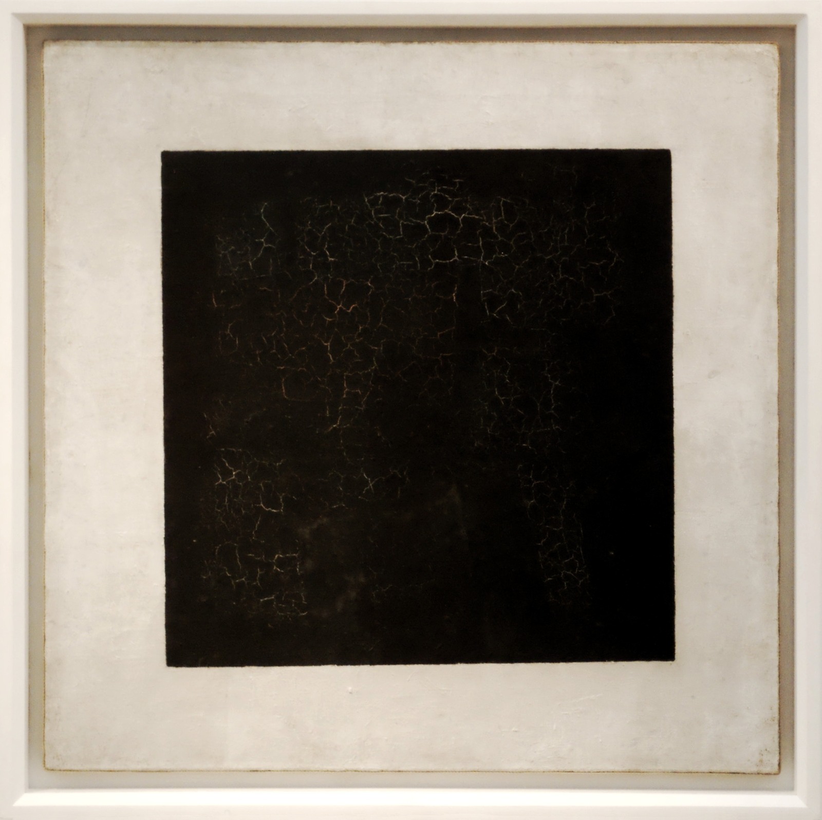 Black painted square with visible cracks inside a light surrounding field.