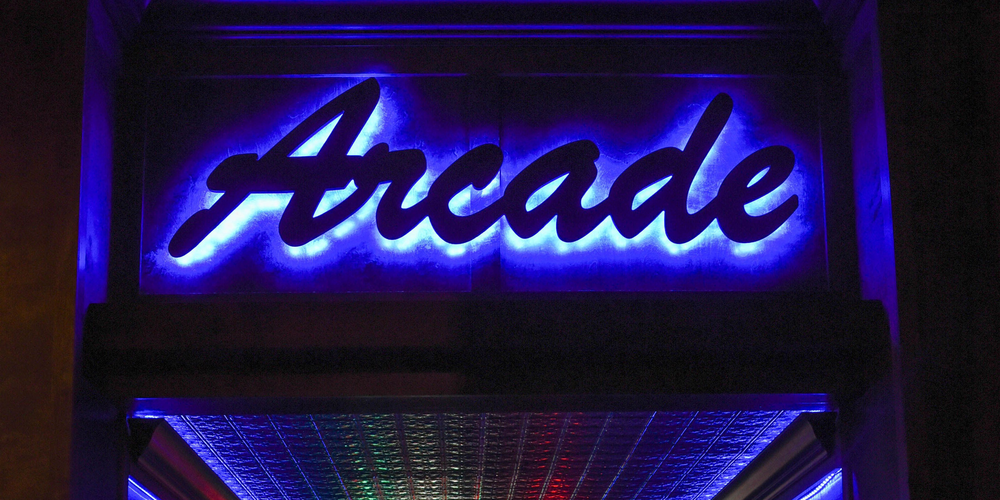 Blue and purple light surrounds a cursive Arcade sign above an entrance.