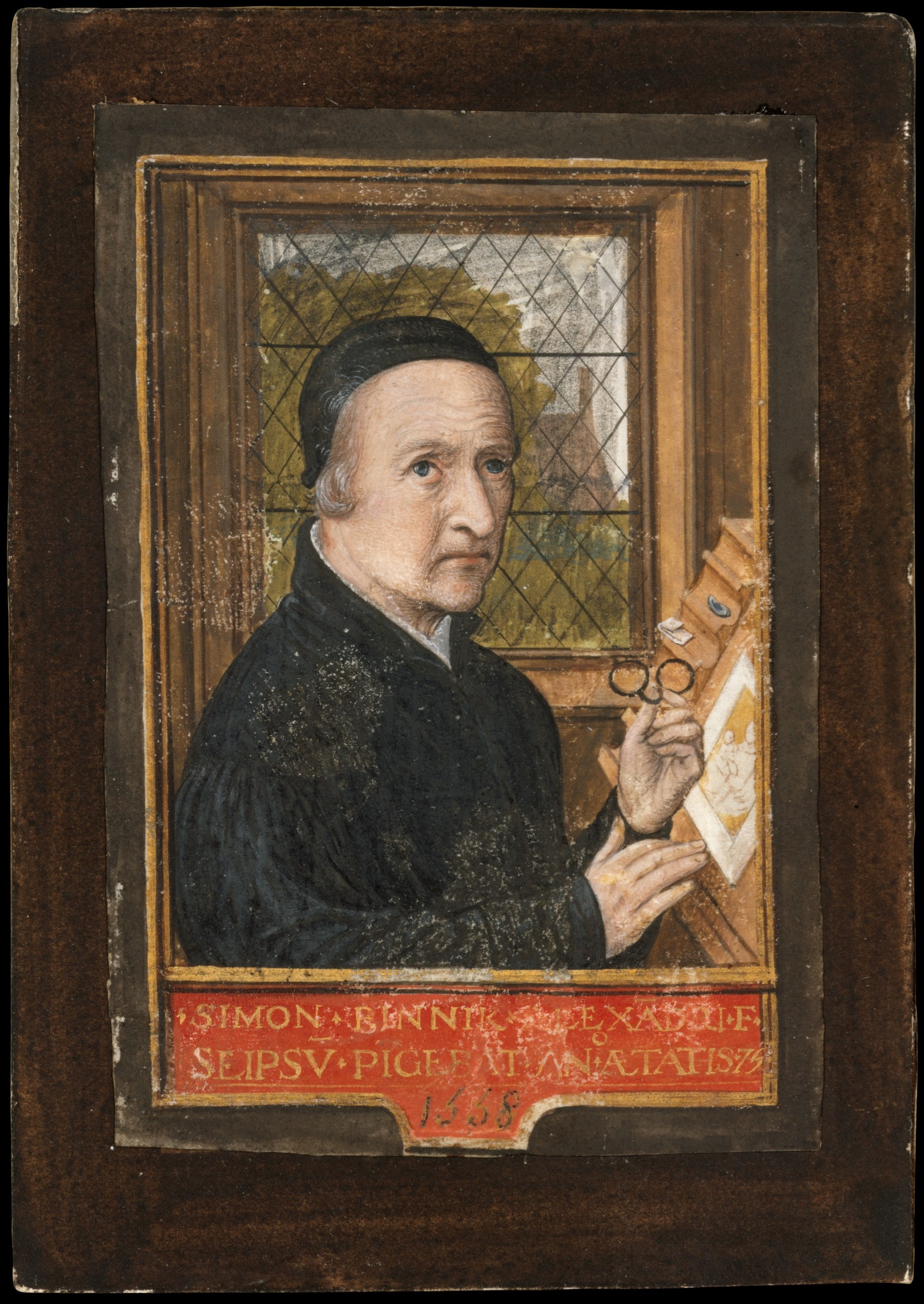 Simon Bening in a black cap holds spectacles before an easel, with a diamond-paned window and a red inscription below, within a dark mount.