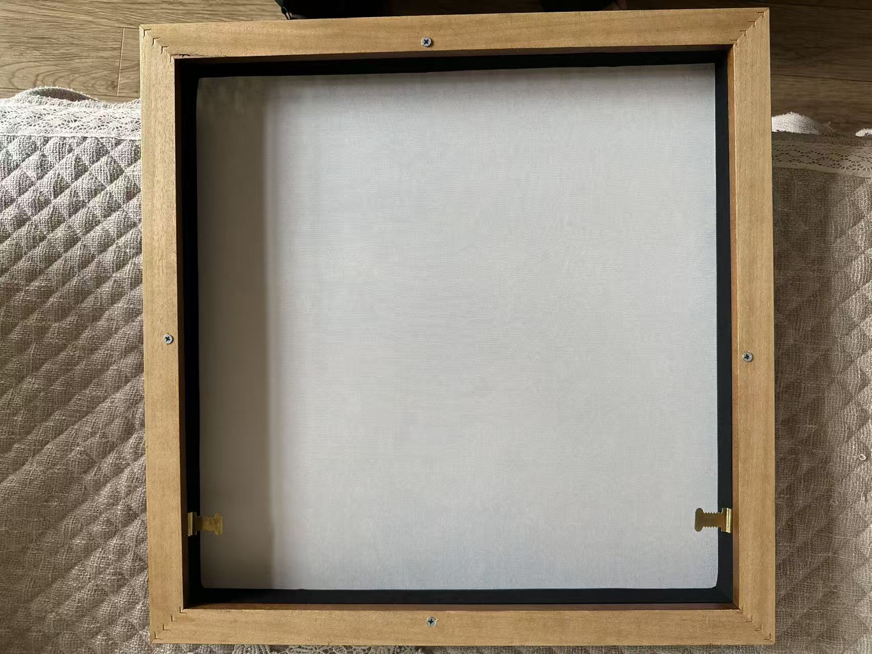 Back of a verified framed Whispart canvas showing the wood frame, joined corners, backing and hanging hardware