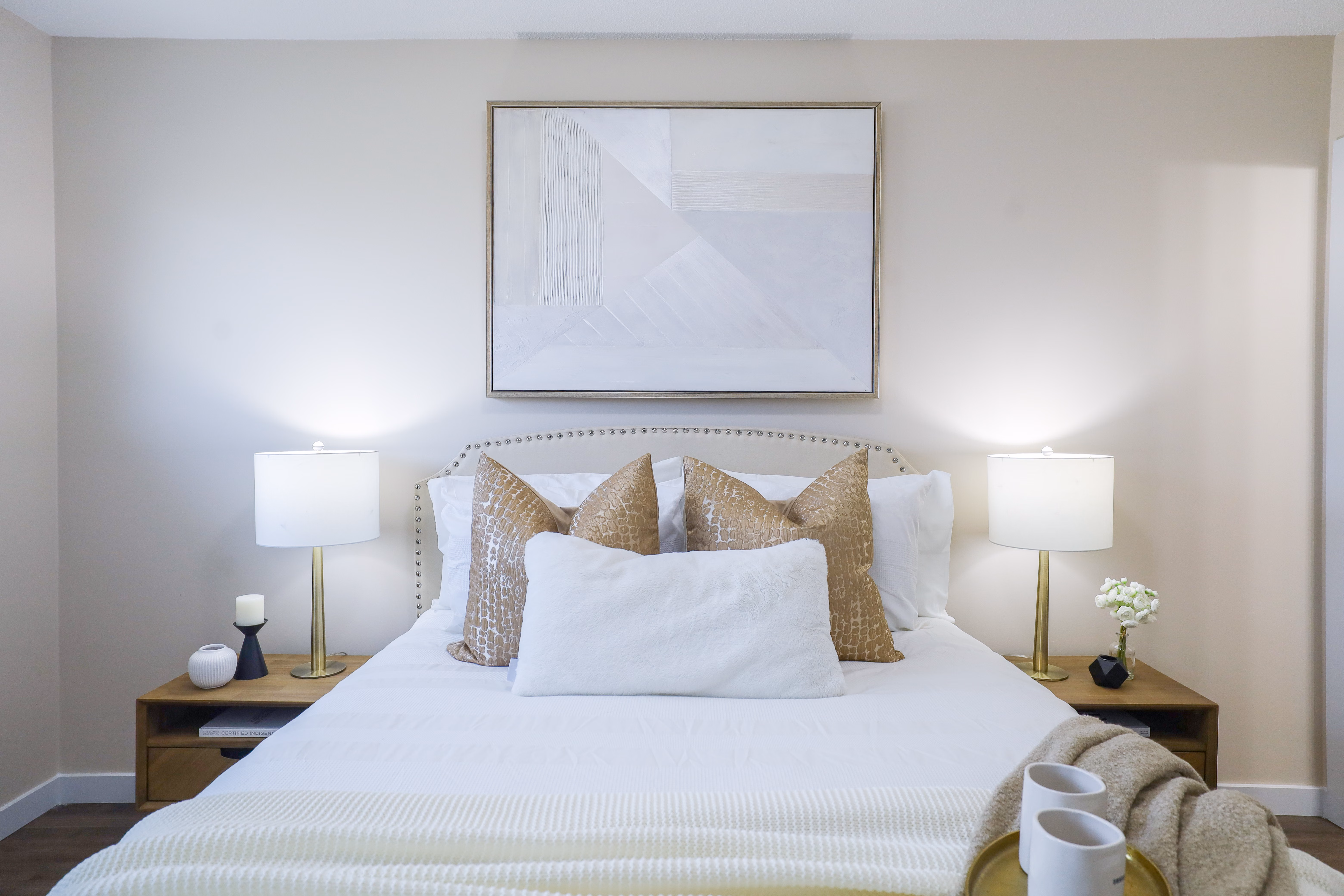 A neutral-toned bedroom with a modern bed and restrained wall decor.