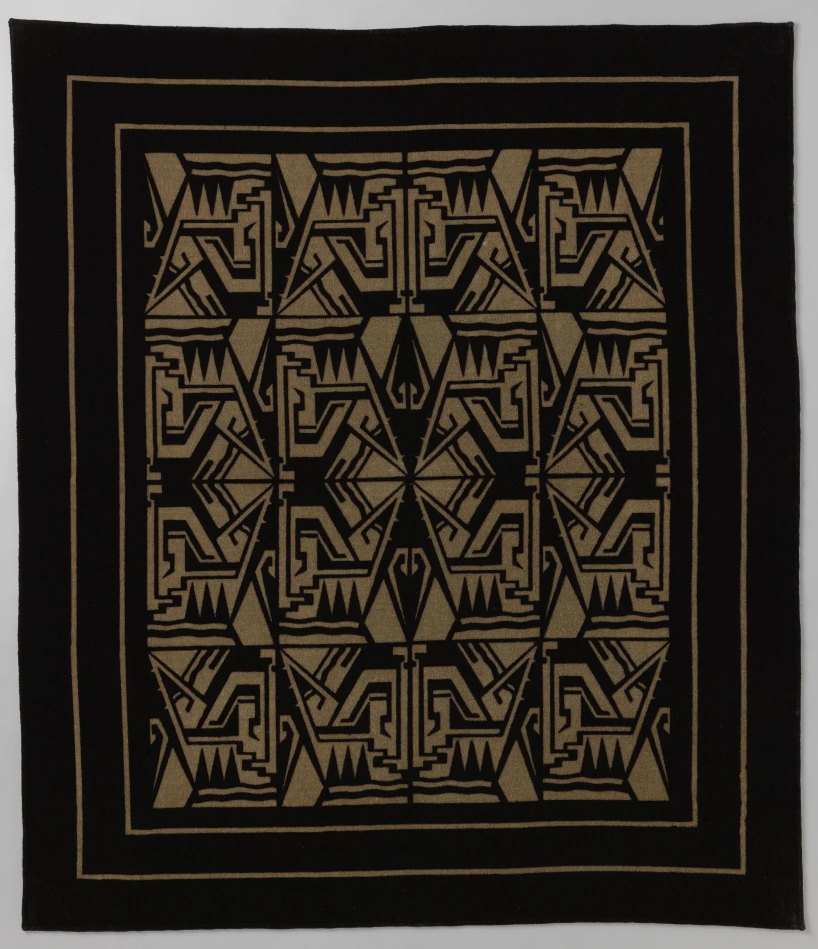 Black printed tablecloth with repeated beige angular Art Deco forms and a plain border, Netherlands, 1920 to 1930.