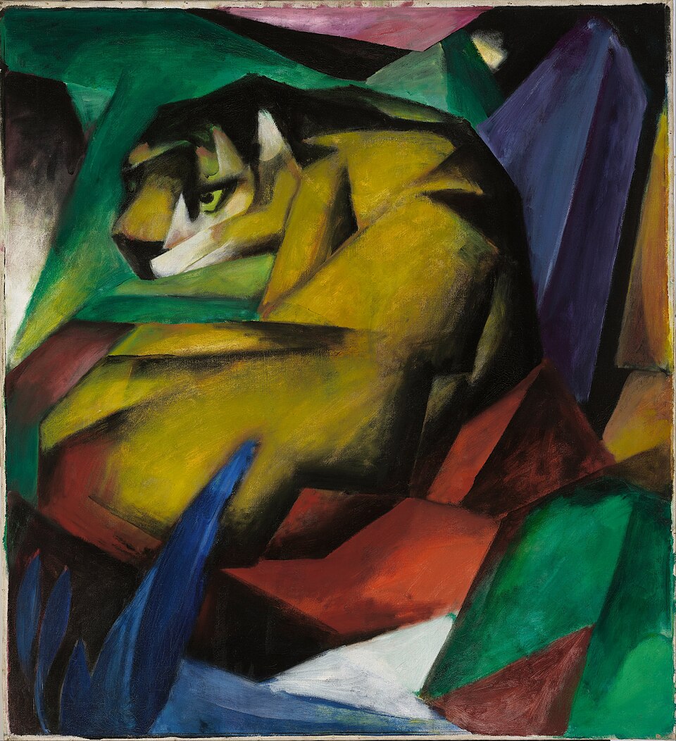 A yellow tiger with broad black stripes curls among sharp green, blue, red and black shapes, its head turned to the left.