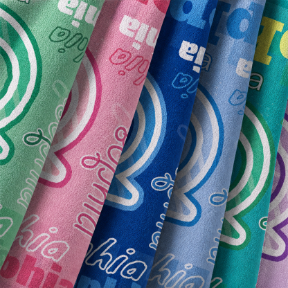 Colorful personalized initial and name beach towels with close up view of soft fabric texture and custom designs