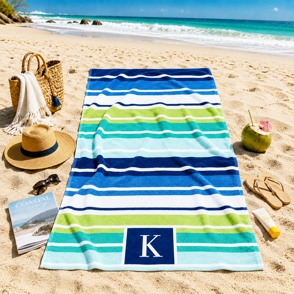 Custom striped monogram beach towel used on the beach for summer vacations and outdoor relaxation