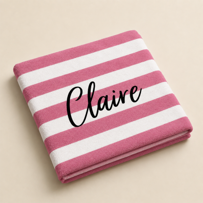 Folded personalized name beach towel showing custom text and striped fabric design
