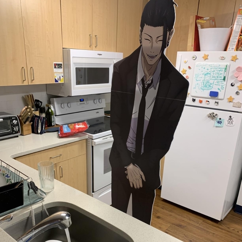 Anime male character in suit life-size cutout standing in home kitchen