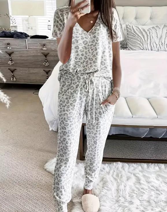 Women's V-NeckLeopard Print Loungewear Set. This relaxed-fit two-piece features a short-sleeve top and pants for effortlessly chic, casual comfort.