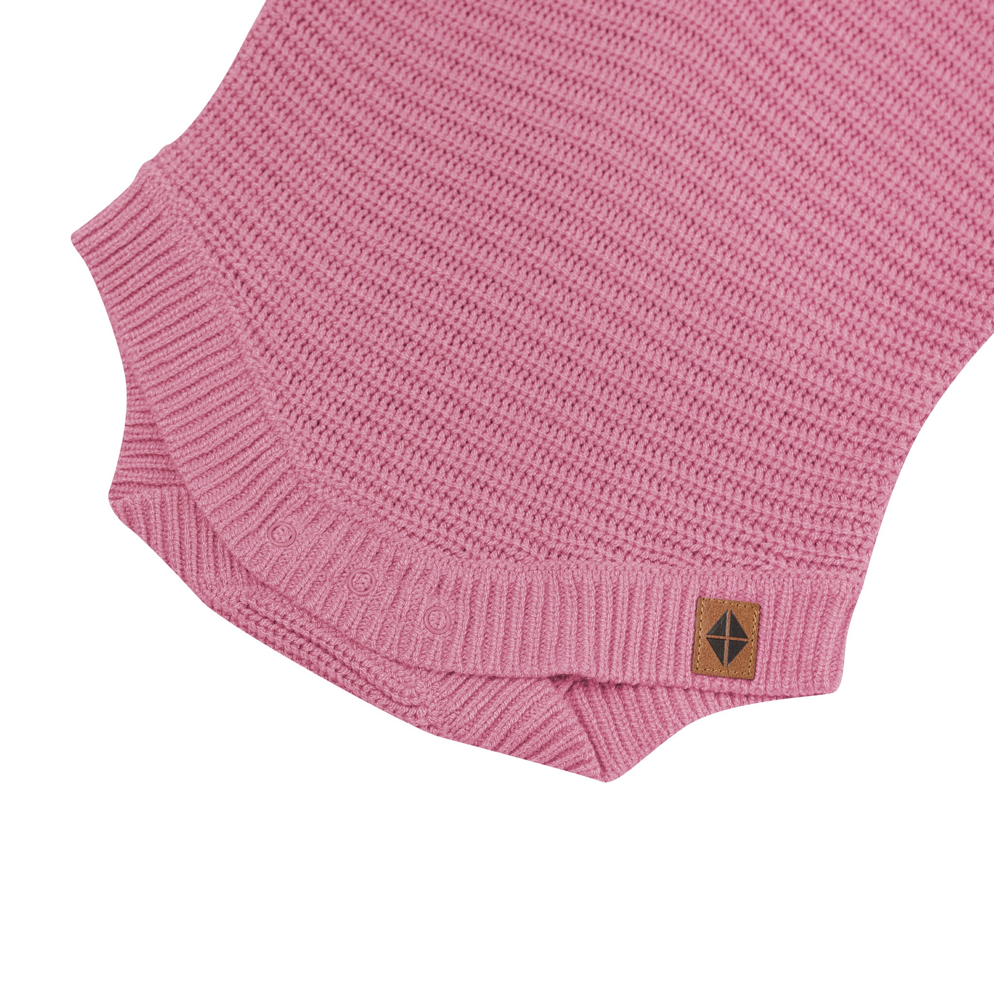 Snap closures shown on the Chunky Knit Romper in Apple Blossom with the Kyte Baby vegan leather tag visible