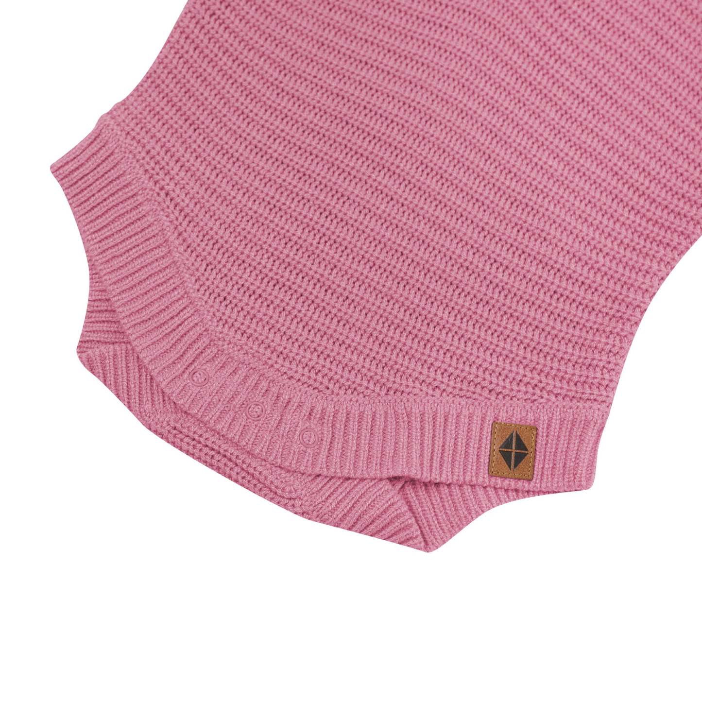 Snap closures shown on the Chunky Knit Romper in Apple Blossom with the Kyte Baby vegan leather tag visible