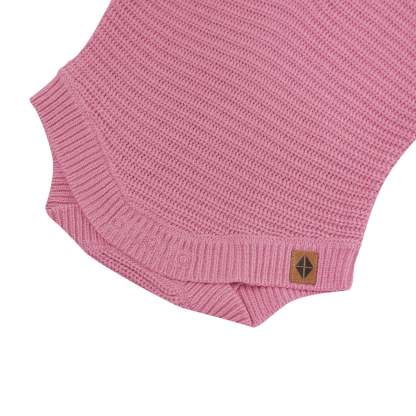 Snap closures shown on the Chunky Knit Romper in Apple Blossom with the Kyte Baby vegan leather tag visible