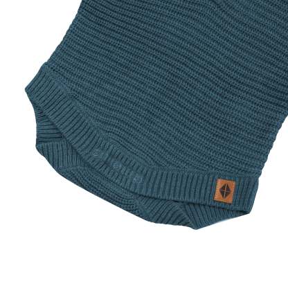 Snap closures shown on the Chunky Knit Romper in Atlantic with the Kyte Baby vegan leather tag visible
